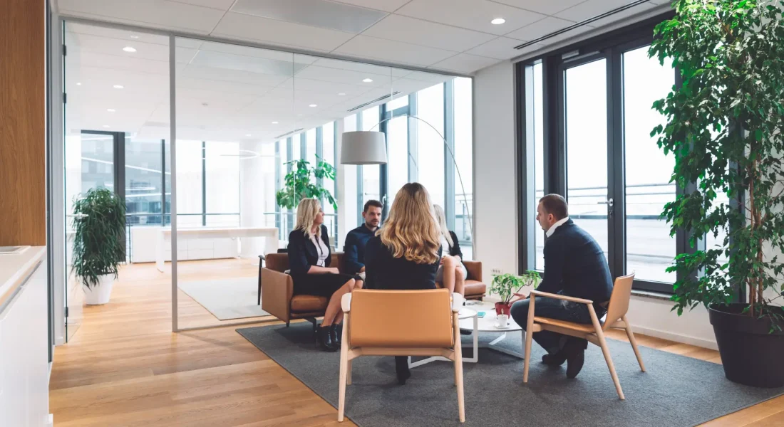 Senior woman director CEO leading in-office training session, collaborative discussion between colleagues. Business people having a meeting in office lounge. People learning and working together to ac